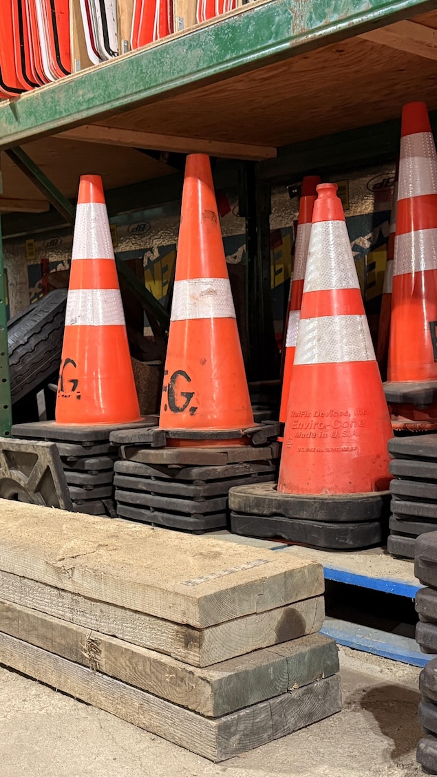 Des cônes de construction sont entreposés dans un garage. 
