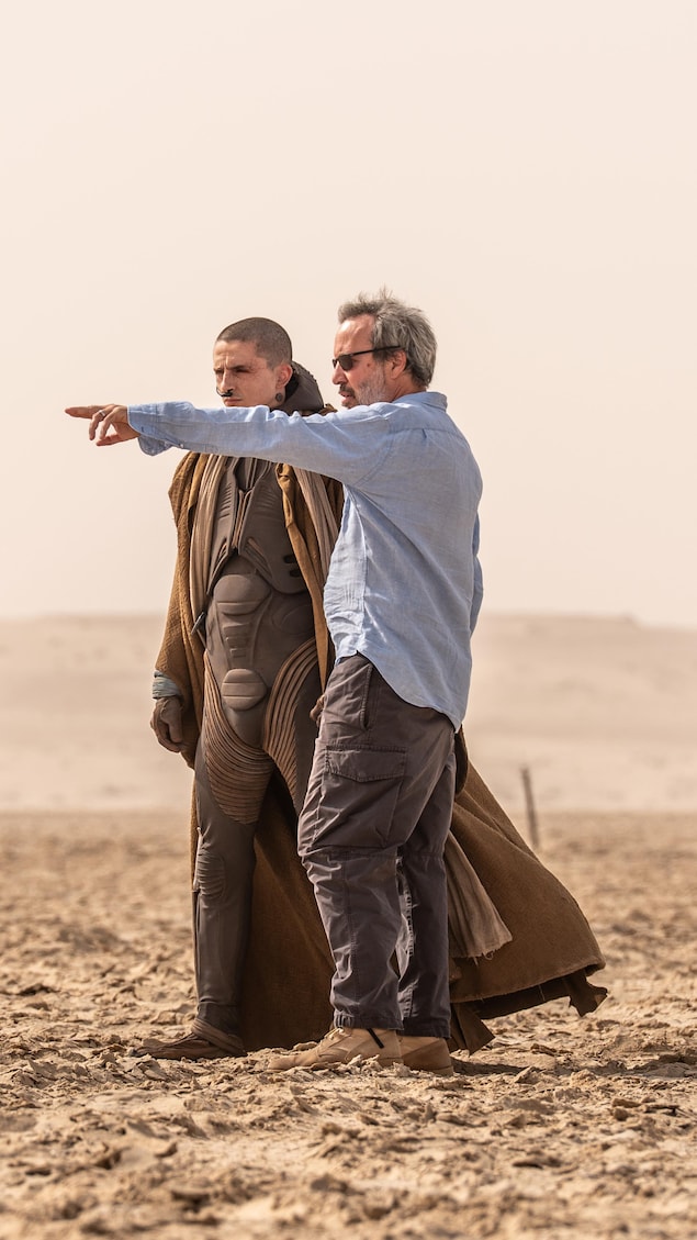 Timothée Chalamet et Denis Villeneuve sont debout dans un désert.