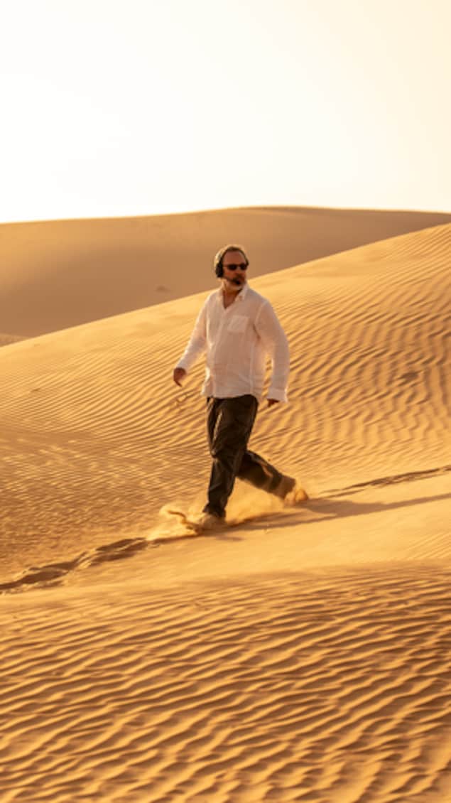 Un homme marche dans le désert.