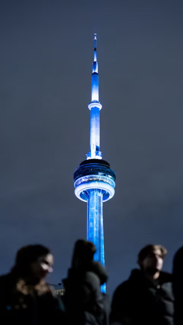 Mga tao nakatingin sa CN Tower na tila nagyelo.