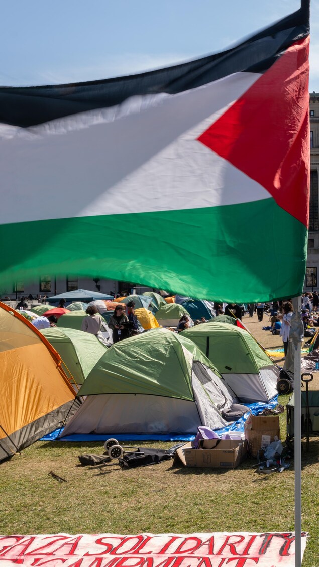 Des étudiants circulent au milieu de dizaines de tentes érigées sur le terrain de l'université.