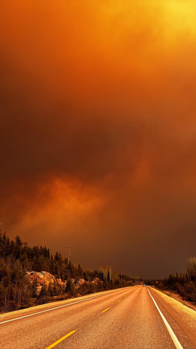 Le ciel est orangé par la fummée des flammes. 