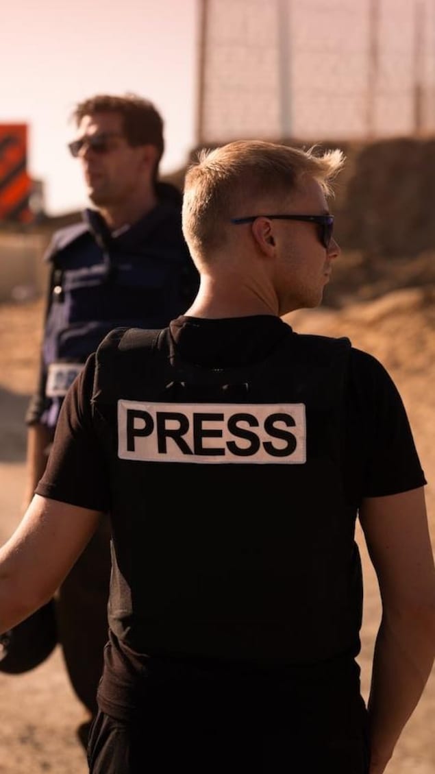Reporters in press vests at a checkpoint.