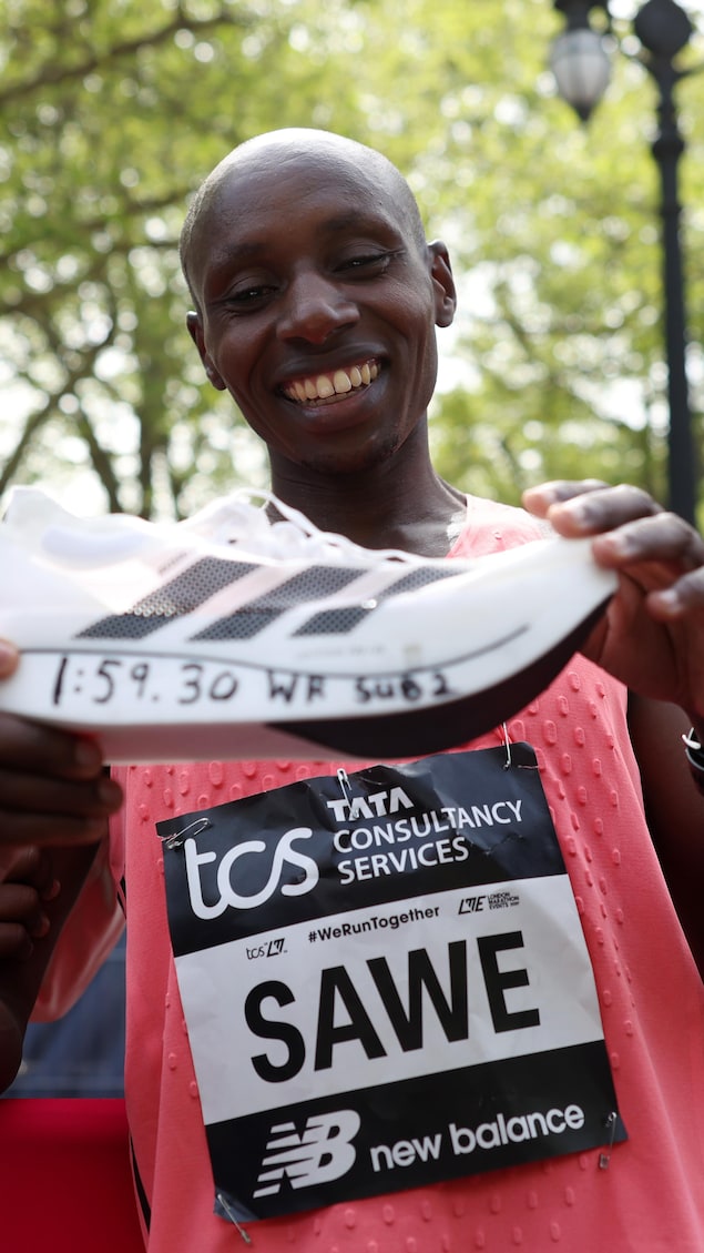 Sabastian Sawe tient sa chaussure.