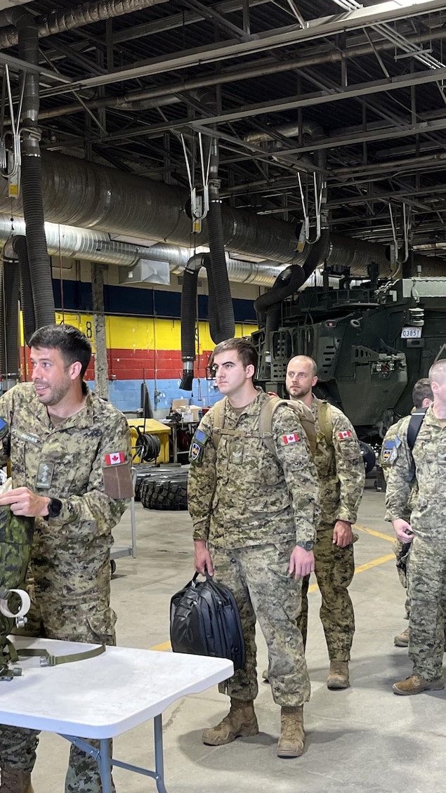 Des militaires en file avec leurs sacs à dos.