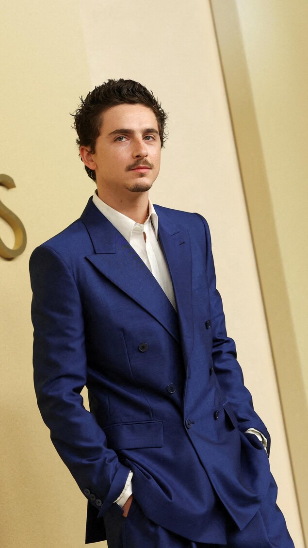 Timothée Chalamet pose devant les photographes.