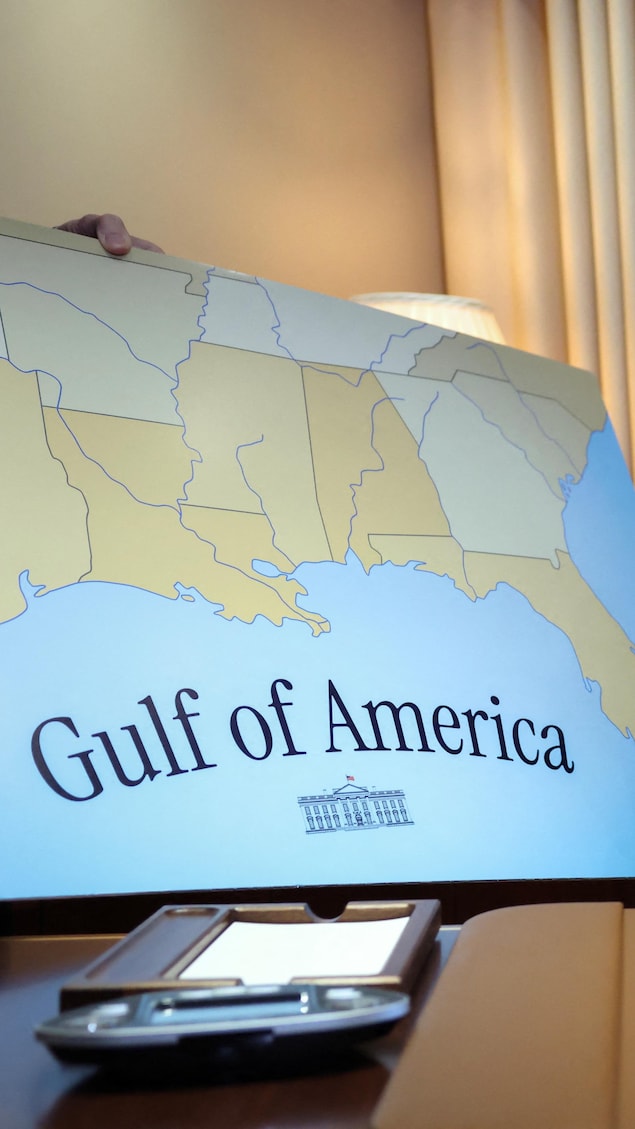 Le président Donald Trump brandit un décret devant une immense carte géographique disant « golfe de l'Amérique ».