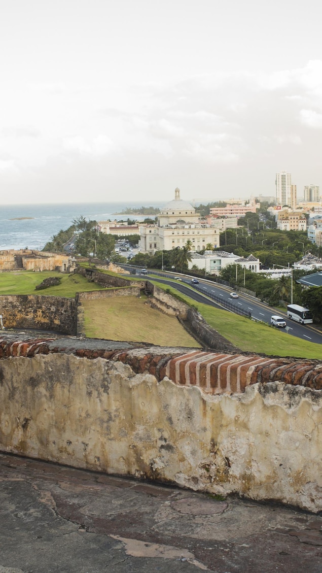 Des passants prennent la pose avec, en toile de fond, le vieux San Juan, à Porto Rico