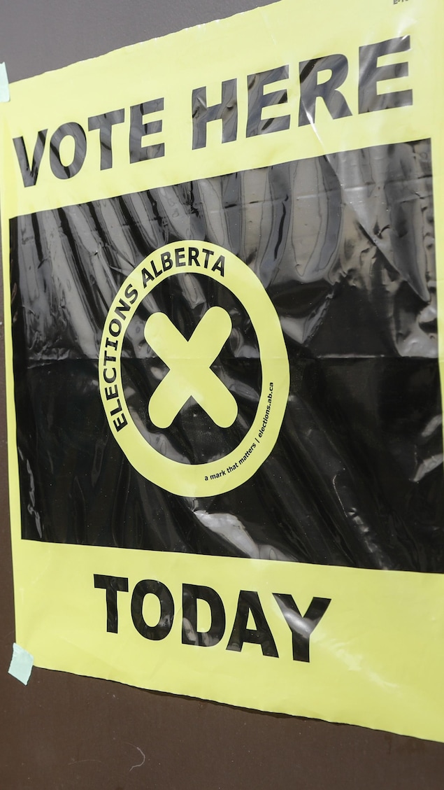 Une personne et une pancarte d'&Eacute;lections Alberta