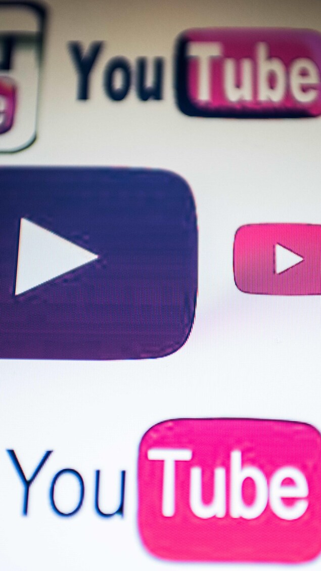 Différents logos de la plateforme YouTube sur un écran.