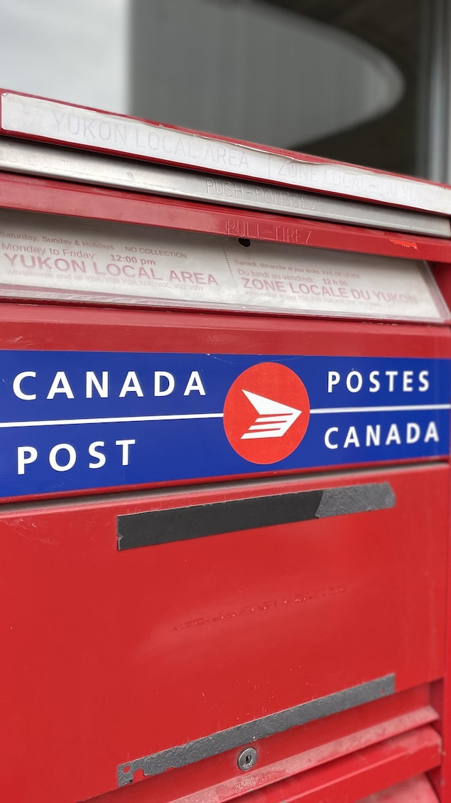 Gros plan sur deux boîtes aux lettres rouges de Postes Canada.