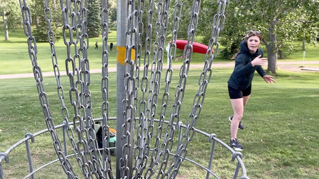 Jo Henderson lance un disque rouge vers une cible sur le terrain de disque-golf Rundle Park.