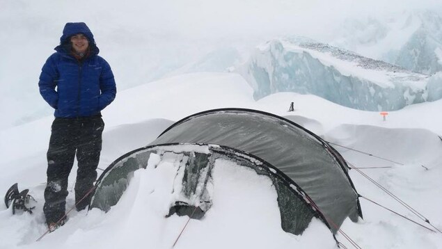 Jean-François est debout à côté de sa tente dans une tempête de neige. Jean-François est debout à côté de sa tente dans une tempête de neige.