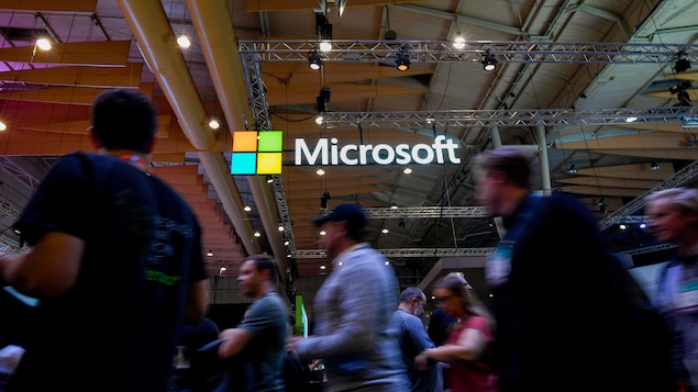 Le logo de Microsoft brille au milieu d'une foule de passants.