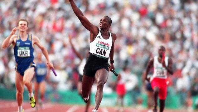 Le Canadien Donovan Bailey lève le doigt vers le ciel alors qu'il franchit le premier le relais masculin de 400 mètres