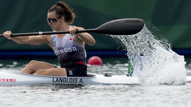 Une femme pagaie dans son kayak.