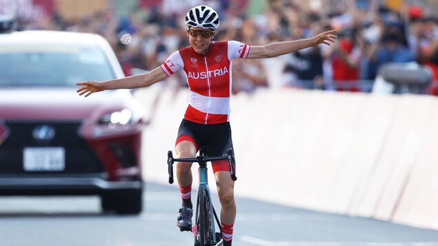 Une cycliste arrive au fil d'arrivée, les bras dans les airs, après une course de 137 km.