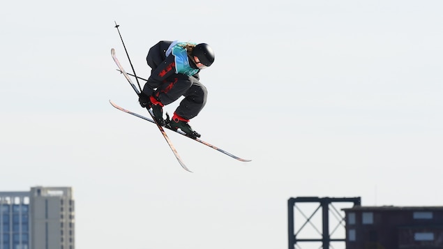 Olivia Asselin prend un de ses skis lorsqu'elle est dans les airs. 