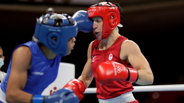 Myriam Da Silva Rondeau qui est en rouge, de l'équipe Canada reçoit un coup de Maria Altagracia Moronta Hernandez, en bleu, de la République Dominicaine durant le combat des femmes poids 64-69 kg.