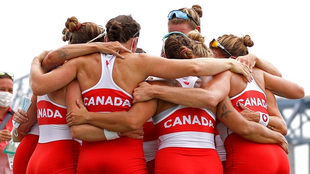 Los miembros del equipo de remo femenino de Canadá se abrazan tras su victoria.