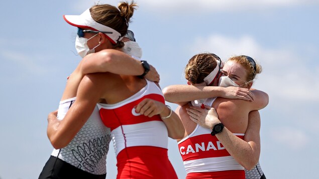 Hillary Janssens et Caileigh Filmer enlacent leur adversaire médaillées d'or.