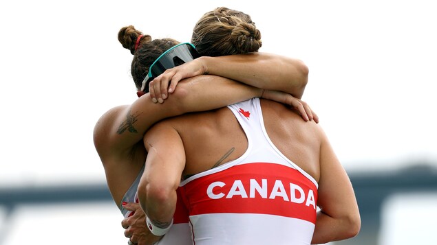 Deux membres de l'équipe canadienne en huite de pointe s'enlacent pour célébrer leur victoire.