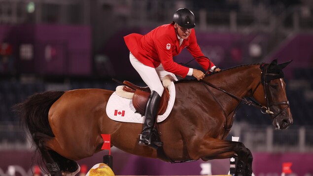 Mario Deslauriers et son cheval qui sautent un obstacle lors des finales.