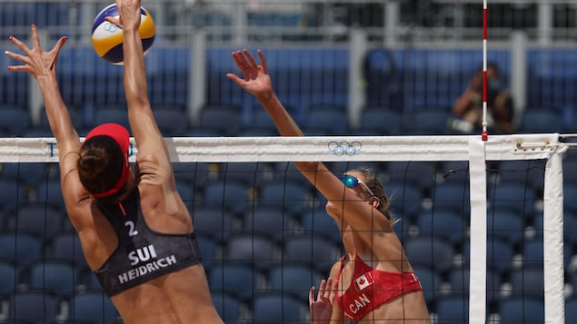 Au filet, Sarah Pavan frappe le ballon et la Suisse Joana Heidrich tente de le bloquer.