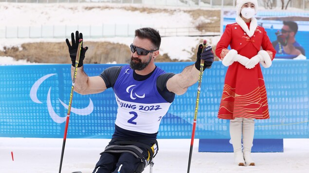 La parafondeur en position assise Collin Cameron salue la foule après une course.