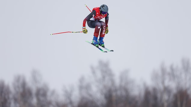 Une skieuse canadienne en plein vol au dessus de la piste de ski cross.