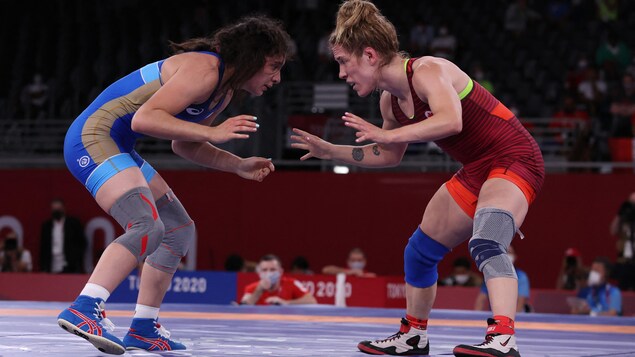 Deux lutteuses olympiques s'étudient, les bras ouverts, attendant le bon moment pour passer à l'attaque.
