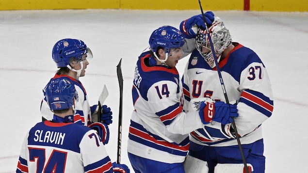 Des joueurs de hockey félicitent leur gardien de but.