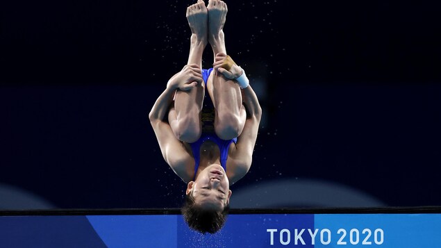 Une plongeuse chinoise effectue un saut arrière en position groupé.