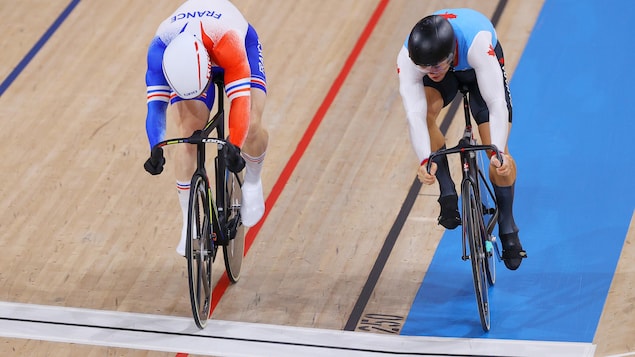 Sebastien Vigier de l'équipe de France et Hugo Barrette de l'équipe du Canada sont en pleine course à vélo lors de la compétition de vitesse individuelle. Ils sont côte à côte devant la ligne devant la ligne d'arrivée.