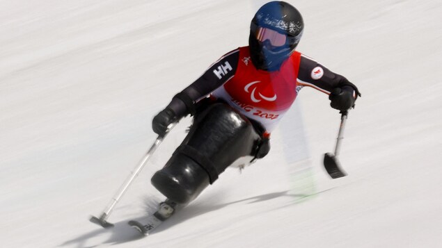 Katie Combaluzier descend le parcours du slalom à toute vitesse en paraski alpin. 