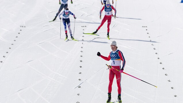Johannes Hoesflot Klaebo, point en avant devant le peleton de tête au skiathlon.