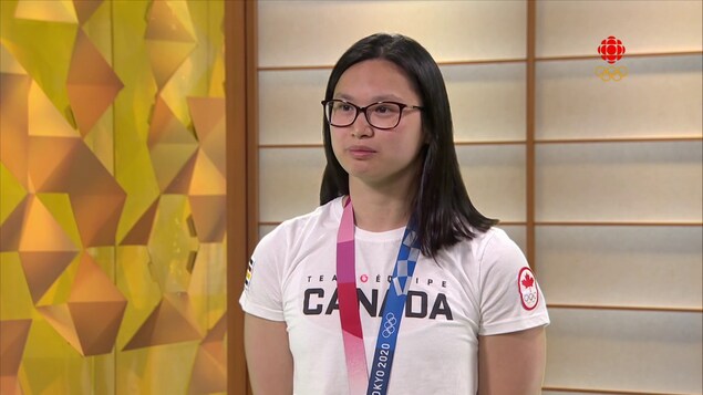 Maggie Mac Neil avec un médaille olympique au cou.