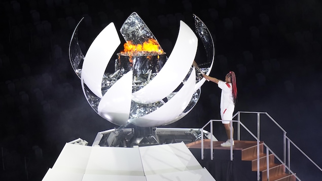 Naomi Osaka allume la vasque avec le flambeau olympique.