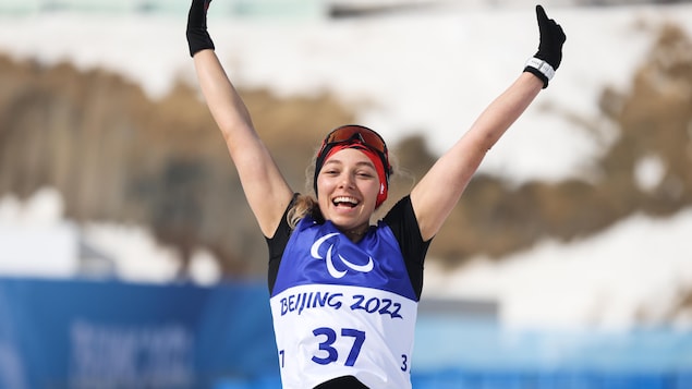 La parafondeuse Natalie Wilkie lève les bras en célébration après avoir remporté une médaille d'or.