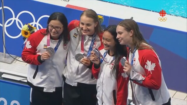 Les quatre nageuses canadiennes prennent la pose avec leur médaille d'argent aux Jeux olympiques de Tokyo.