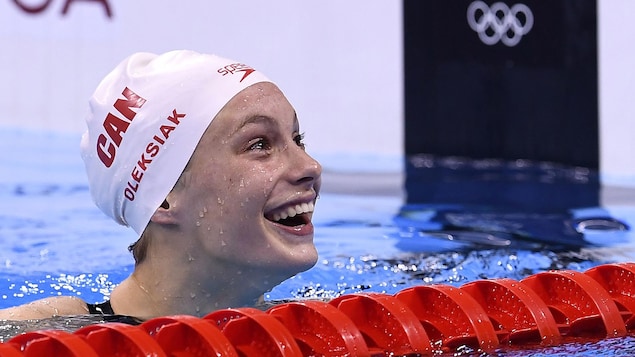 La nageuse canadienne Penny Oleksiak affiche un grand sourire dans la piscine olympique. 