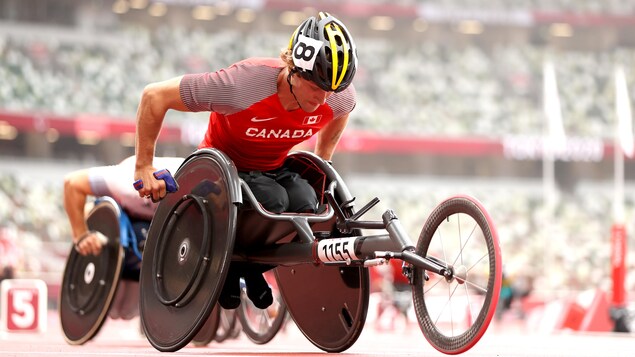 L'athlète s'est penché dans son fauteuil roulant se tenant prêt pour s'élancer dès le coup du départ de la course.