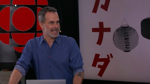 Un homme explique quelque chose sur un plateau de tournage.