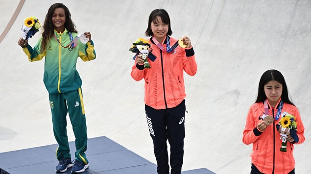 Rayssa Leal, Momiji Nishiya et Funa Nakayama posent avec leur médaille sur le podium.