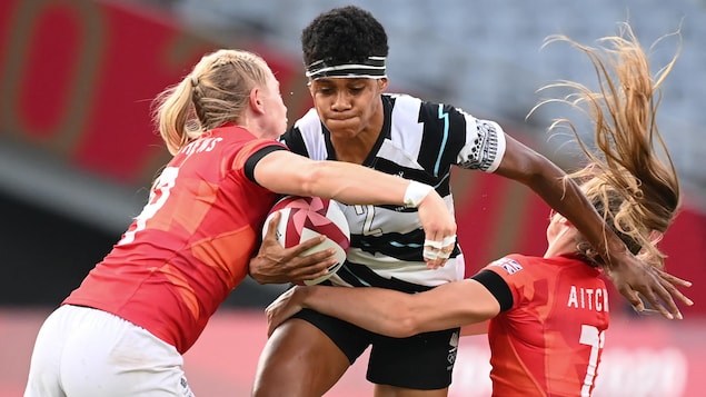 La capitaine Sesenieli Donu porte le ballon et se fait plaquer par deux joueuses de la Grande-Bretagne.