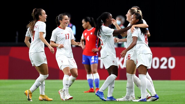 Les joueuses s'enlacent avec un grand sourire après un but.