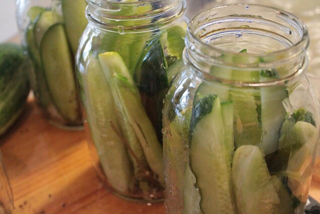 Les cornichons frais sont déposés dans des bocaux en verre ouverts. Les cornichons frais sont déposés dans des bocaux en verre ouverts.