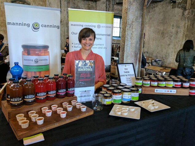 Christine Manning sur un stand d'exposition présente ses produits. Christine Manning sur un stand d'exposition présente ses produits.