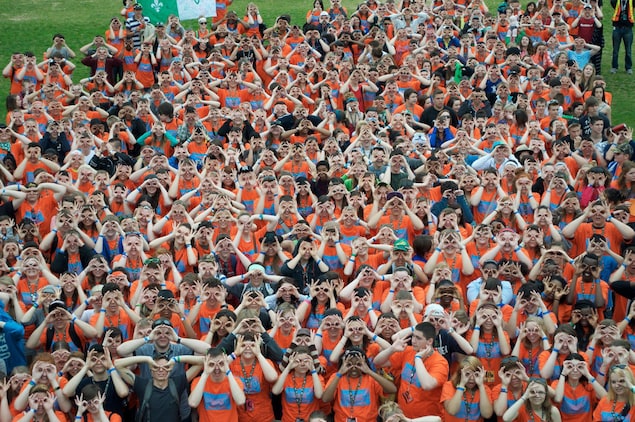 Une foule de jeunes gens qui miment des lunettes avec leurs doigts. Une foule de jeunes gens qui miment des lunettes avec leurs doigts.