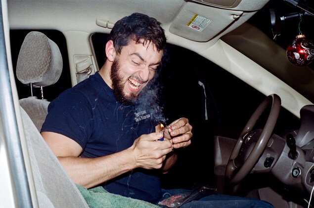 Une photo de François, derrière le volant de sa voiture, qui allume un pétard Une photo de François, derrière le volant de sa voiture, qui allume un pétard